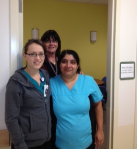 Theresa (Terri) Karapita, PCC, Baldish Virk, RN, and Julia Bergen, RN pose in the doorway of their interim medication room.